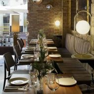 ABBACUS High table lamp in matt gold Die dekorative Leuchte in einem Restaurant.